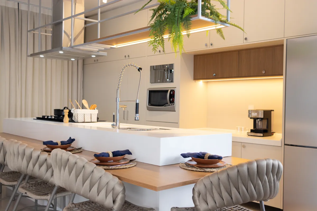 Cozinha gourmet com ilha, banquetas e armários iluminados